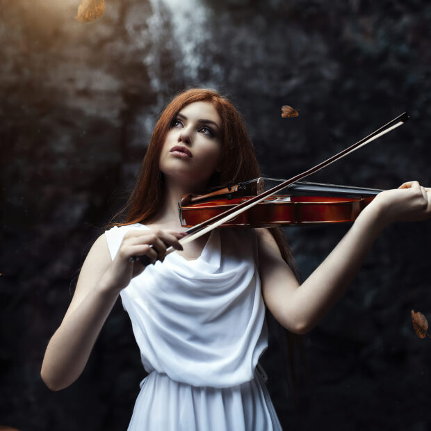 A red haired woman plays a violin surrounded by dark natural scenery, HD Mobile Wallpaper