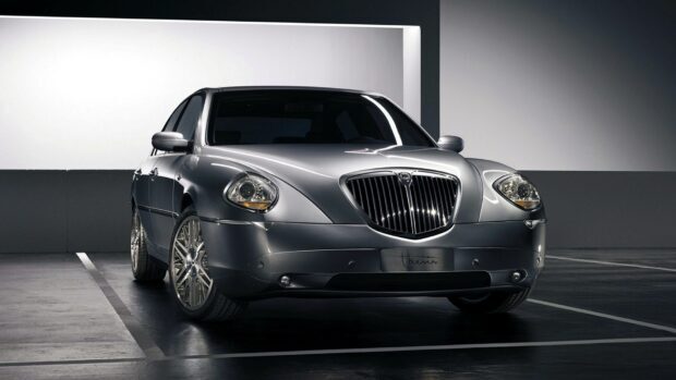 The sleek silver Lancia car is parked in a modern garage setting, HD Desktop Wallpaper