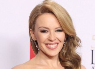 Kylie Minogue shows an elegant smile with wavy blonde hair at an award event, HD Desktop Wallpaper