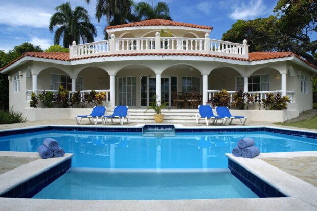An elegant villa with a refreshing pool surrounded by palm trees in the Dominican Republic, HD Desktop Wallpaper