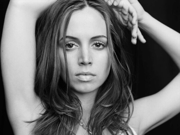 Eliza Dushku in a close up black and white portrait with her arms raised above her head