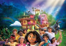 The Encanto family stands together near a colorful magical house with animals and butterflies, 2K Mobile Wallpaper