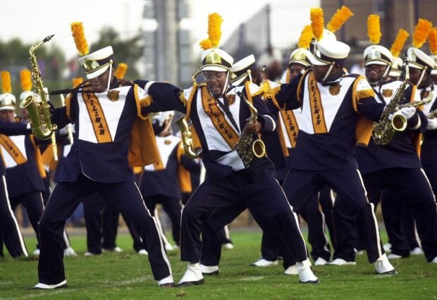 The marching band performs in vibrant uniforms with instruments on the field, HD Desktop Wallpaper