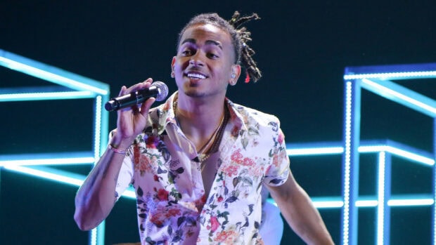 Ozuna performing on stage with a microphone and floral shirt, HD Desktop Wallpaper