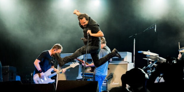 Pearl Jam delivers an energetic live performance on stage with dynamic movements and musical instruments
