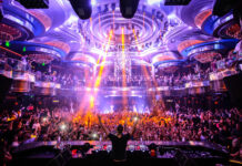 A DJ performs in front of a large crowd enjoying the vibrant nightclub atmosphere, HD Desktop Wallpaper