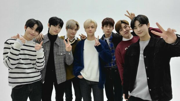 The Enhypen members show hand signs and pose for a group photo in casual outfits, HD Desktop Wallpaper