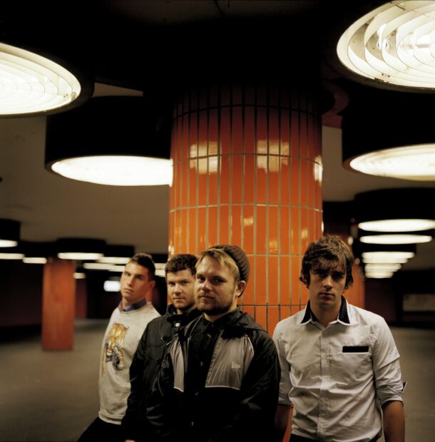 The Enter Shikari Band stands together in a corridor with orange tiled pillars, HD Desktop Wallpaper