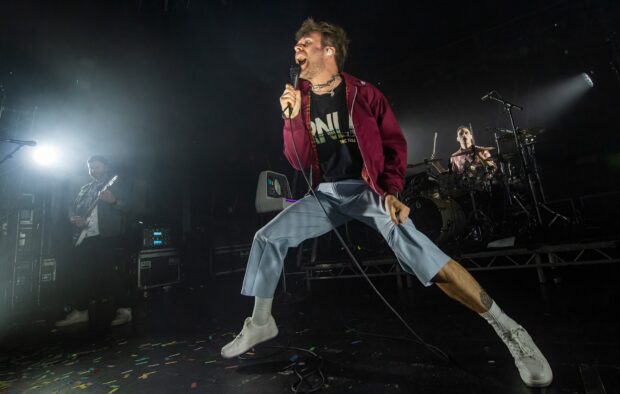 The lead singer of Enter Shikari Band passionately performs on stage during a live concert, HD Desktop Wallpaper