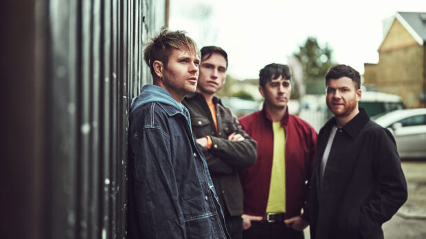 The Enter Shikari band members stand near a fence in an outdoor urban setting, HD Desktop Wallpaper