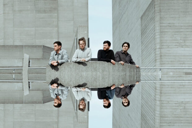 The Enter Shikari band members are standing by a large concrete wall in an urban setting, HD Desktop Wallpaper