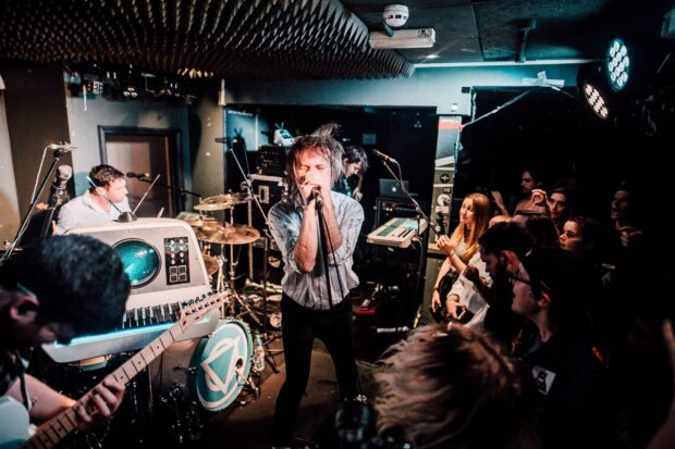 The Enter Shikari band is performing passionately during a live concert in an intimate venue, HD Desktop Wallpaper