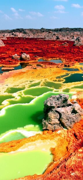 The Ethiopian landscape shows vivid colors with green, yellow, and red volcanic formations under a blue sky, 2K Mobile Wallpaper