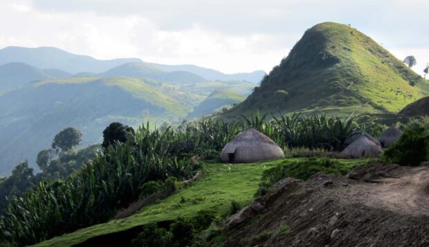 A peaceful view of Ethiopian highlands with lush greenery and traditional thatched huts, HD Desktop Wallpaper