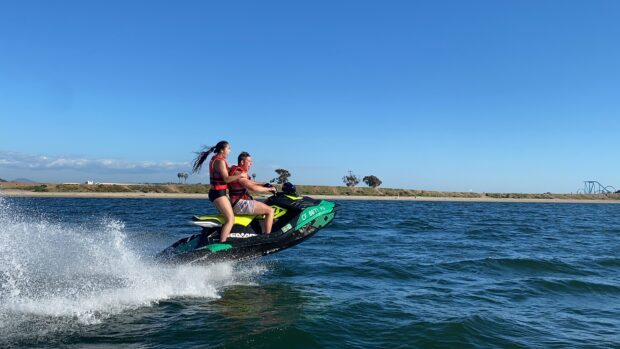 A couple riding a jet ski during a sunny day on the water, 4K Desktop Wallpaper