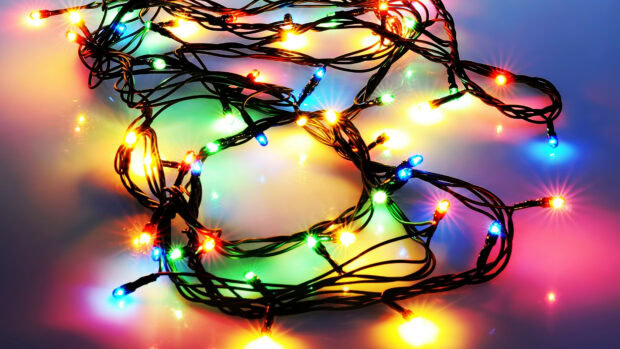 Colorful fairy lights tangled together creating a vibrant glow on a smooth surface