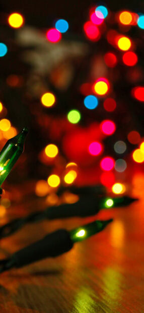 Close up of fairy lights creating colorful bokeh effects on a wooden surface