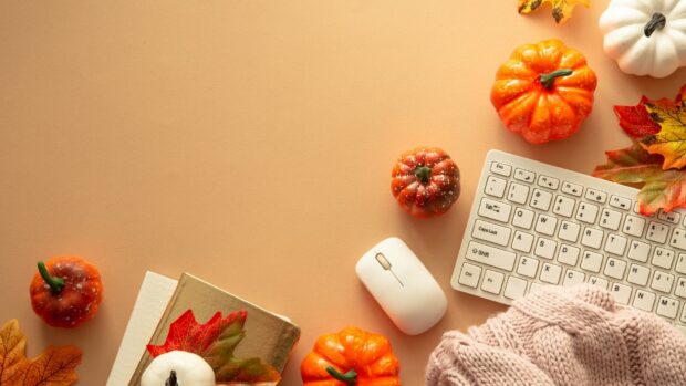 A cozy office desk decorated with pumpkins and autumn leaves for Fall