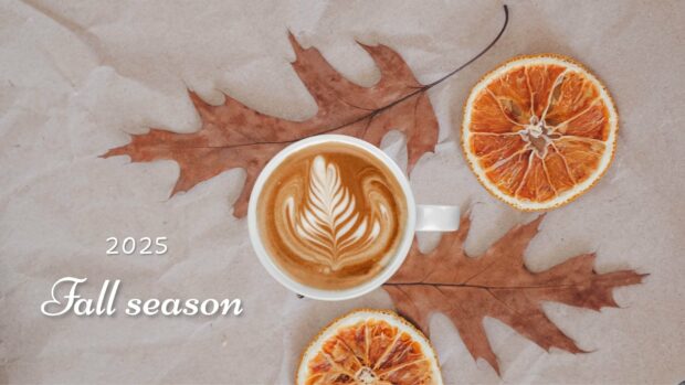 A cup of latte art on a large autumn leaf celebrating the 2025 Fall season