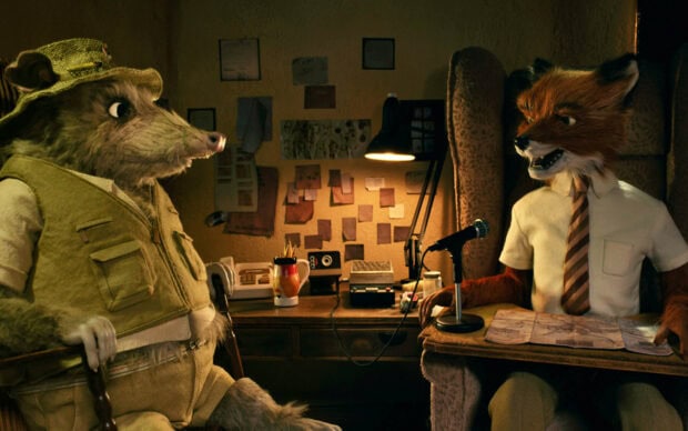 The Fantastic Mr Fox characters sit by a desk in a cozy room discussing plans