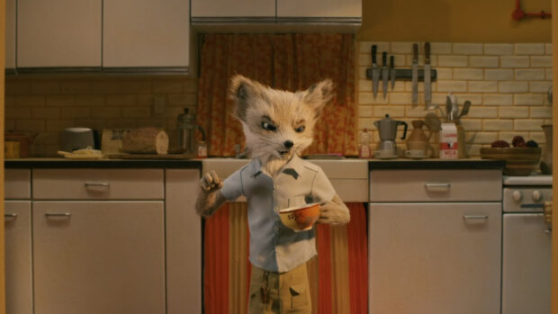 A detailed Fantastic Mr Fox character standing in a kitchen holding a cup and wearing a shirt