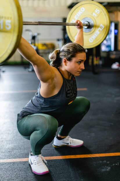 A female athlete is performing a clean and jerk lift during Crossfit training, HD Mobile Wallpaper