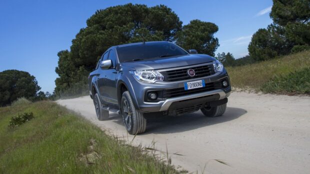 A Fiat Fullback is driving on a dusty rural road surrounded by grass and trees, HD Desktop Wallpaper