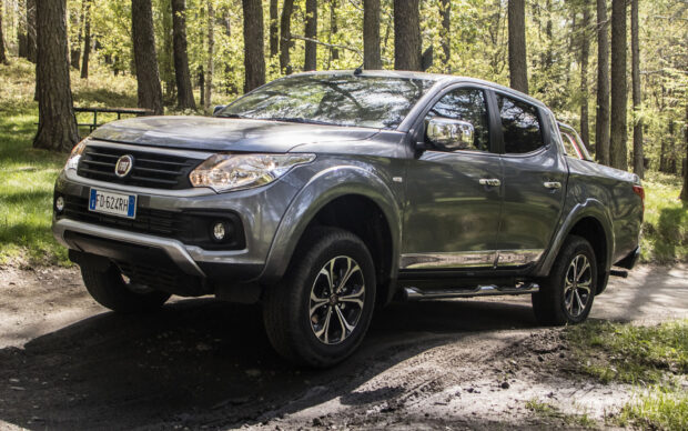 A Fiat Fullback drives along a forest trail surrounded by tall trees and greenery, HD Desktop Wallpaper