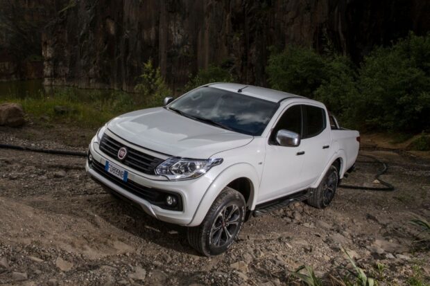 A white Fiat Fullback truck is parked on rugged ground near cliffs and bushes, HD Desktop Wallpaper