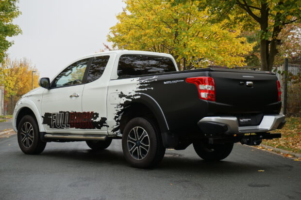A Fiat Fullback pickup truck is parked on the street with autumn trees in the background, 2K Desktop Wallpaper