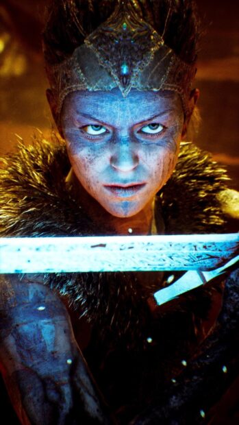 The fierce warrior with blue war paint holds a glowing sword in a focused stance, HD Phone Wallpaper