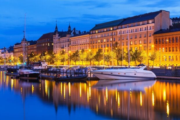 Boats docked along the harbor in Finland during twilight showing classic European architecture