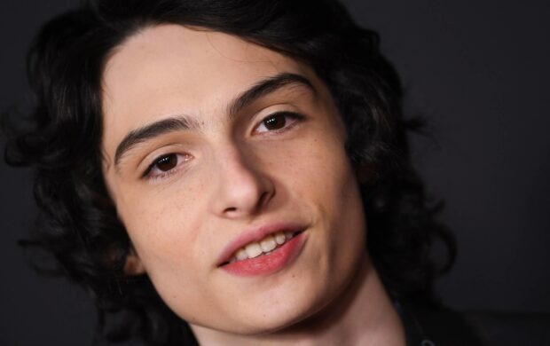 Finn Wolfhard close up portrait with curly dark hair and relaxed expression, 2K Desktop Wallpaper