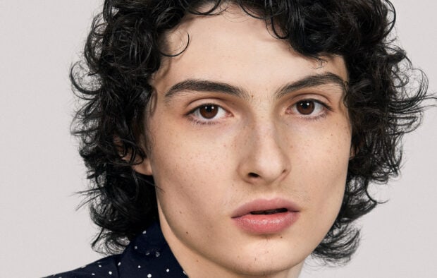 A close up portrait of Finn Wolfhard with brown eyes and curly hair, HD Desktop Wallpaper