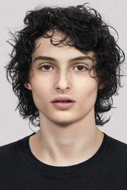 A close up portrait of Finn Wolfhard with curly hair and a neutral expression, HD Phone Wallpaper