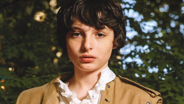 A close up portrait of Finn Wolfhard wearing a beige jacket in a natural outdoor setting, HD Desktop Wallpaper