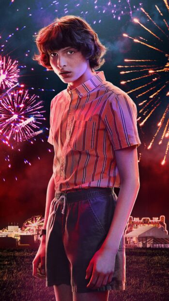 Finn Wolfhard stands in front of colorful fireworks at night, 4K Phone Wallpaper