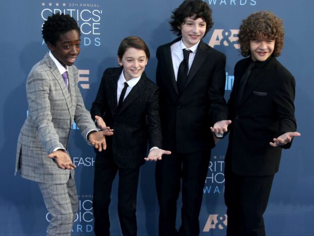 Finn Wolfhard with cast members posing at an award event, HD Desktop Wallpaper