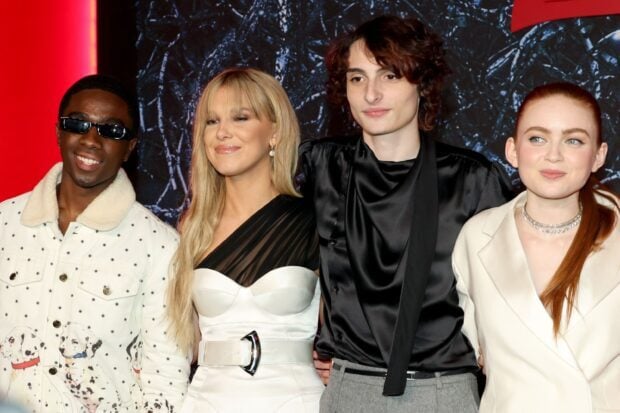 Finn Wolfhard poses with co stars at a public event wearing stylish outfits, 2K Desktop Wallpaper