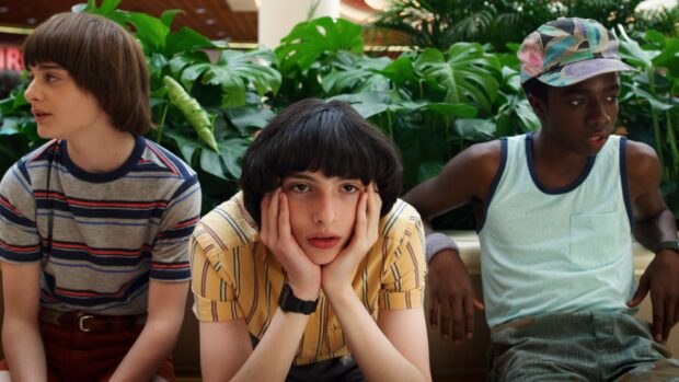Finn Wolfhard sits with hands on face beside two friends, HD Desktop Wallpaper