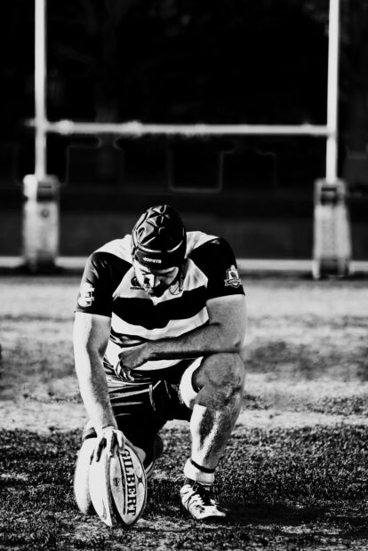 A rugby player is preparing to kick the ball on the field during a match, HD Mobile Wallpaper