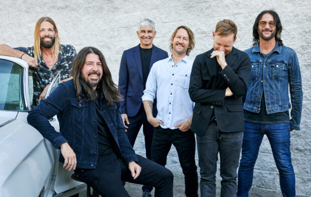 The Foo Fighters band members stand smiling together against a white wall, 2K Desktop Wallpaper