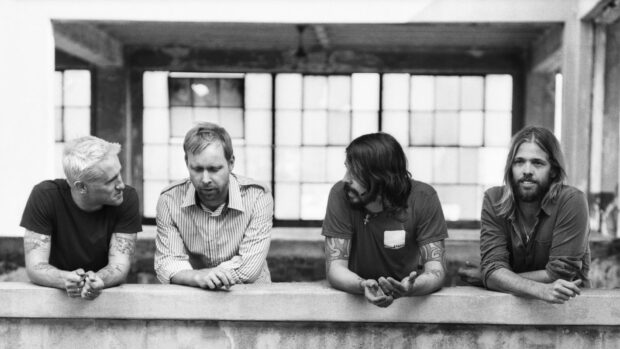 Foo Fighters band members talking near a concrete ledge in an industrial building, HD Desktop Wallpaper