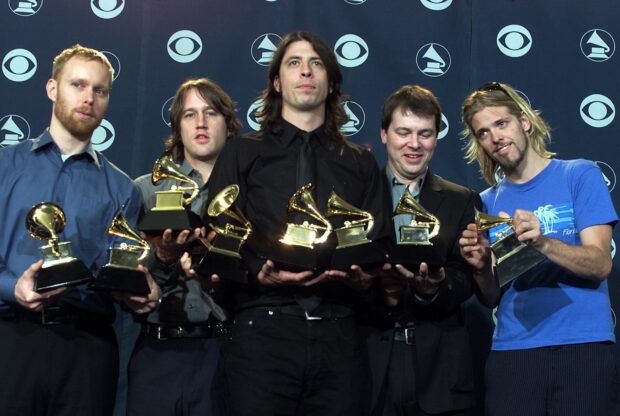 Foo Fighters band members holding multiple Grammy trophies at an event, HD Desktop Wallpaper