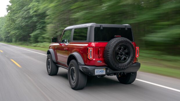 Red Ford Bronco driving fast on a forest road in high resolution 2K