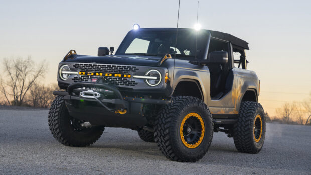 Ford Bronco off road vehicle with yellow accents on wheels and grille at sunset