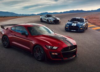 Red Ford Mustang car with two other models parked on race track curves