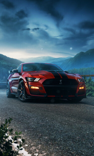 A red Ford Mustang parked on a mountain road under a cloudy sky in high definition