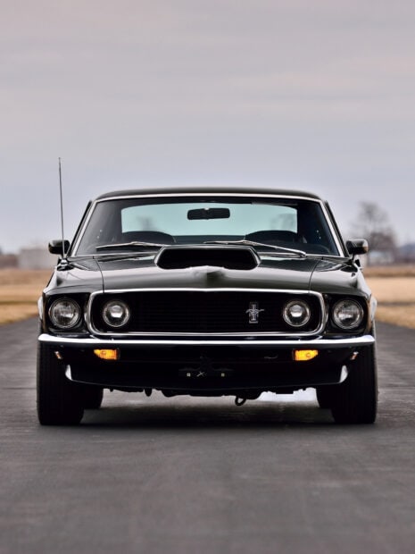 Classic Ford Mustang car front view on road with headlights on