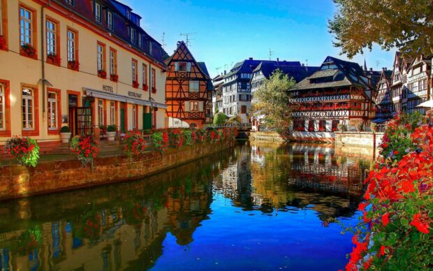 Traditional France architecture reflection in clear river water during autumn season